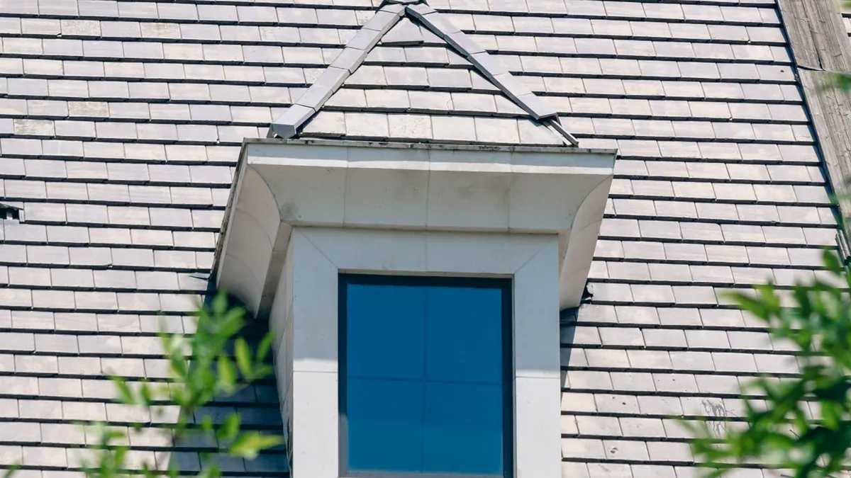 New England Cape Cod style roof with a dormer, a common roofing job in Massachusetts and Connecticut